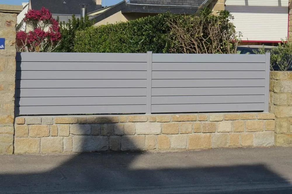 Clôture en aluminium gris à lames horizontales sur un muret en pierre