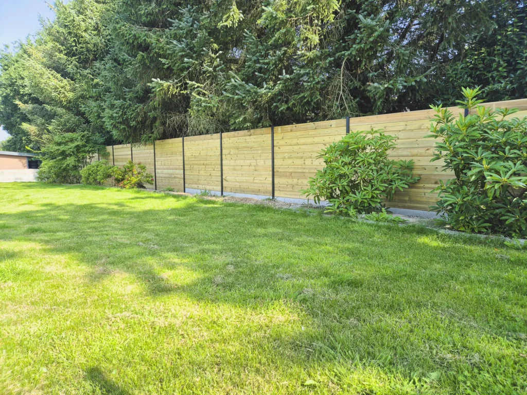 Clôture en bois à lames horizontales installée dans un jardin